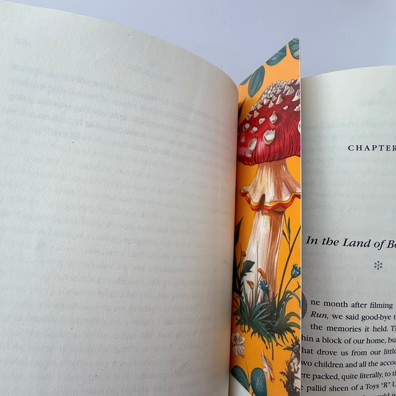 Yellow mushroom bookmark in crease of an open book.