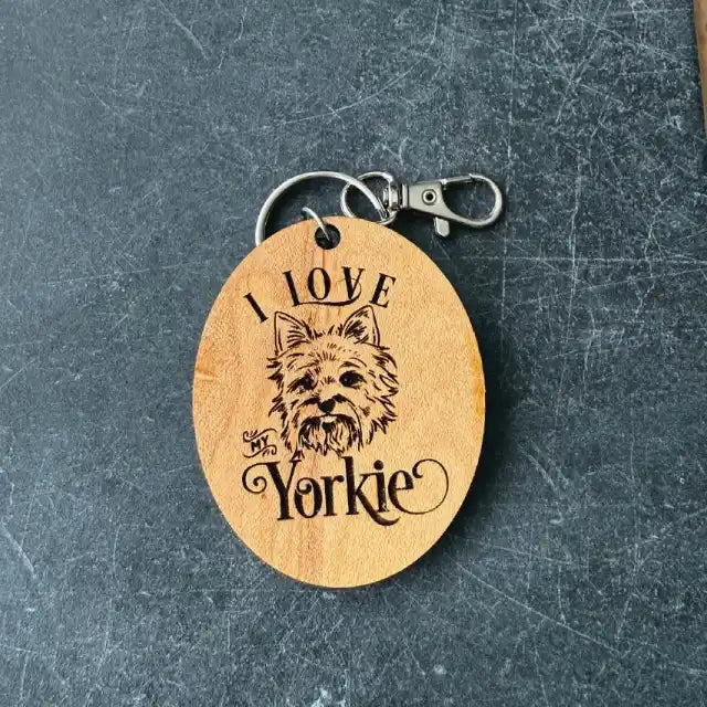 Wooden keychain with 'I Love Yorkie' engraving on a dark textured surface