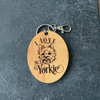 Wooden keychain with 'I Love Yorkie' engraving on a dark textured surface