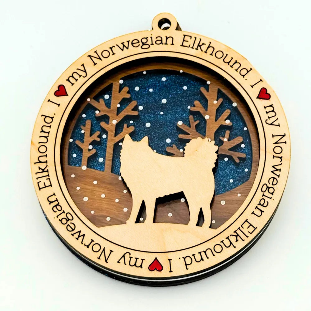 Decorative ornament with a silhouette of a Norwegian Elkhound on a dark blue background and engraved text on a white background