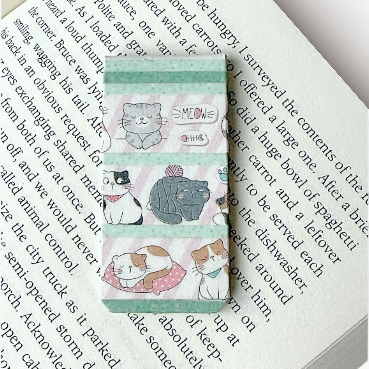 Magnetic bookmark with cat designs on a book page background