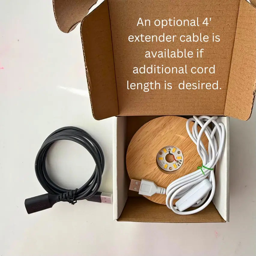 a black cable on a light background with a box holding a light base with cord and text that says an optional 4' extender cable is available.