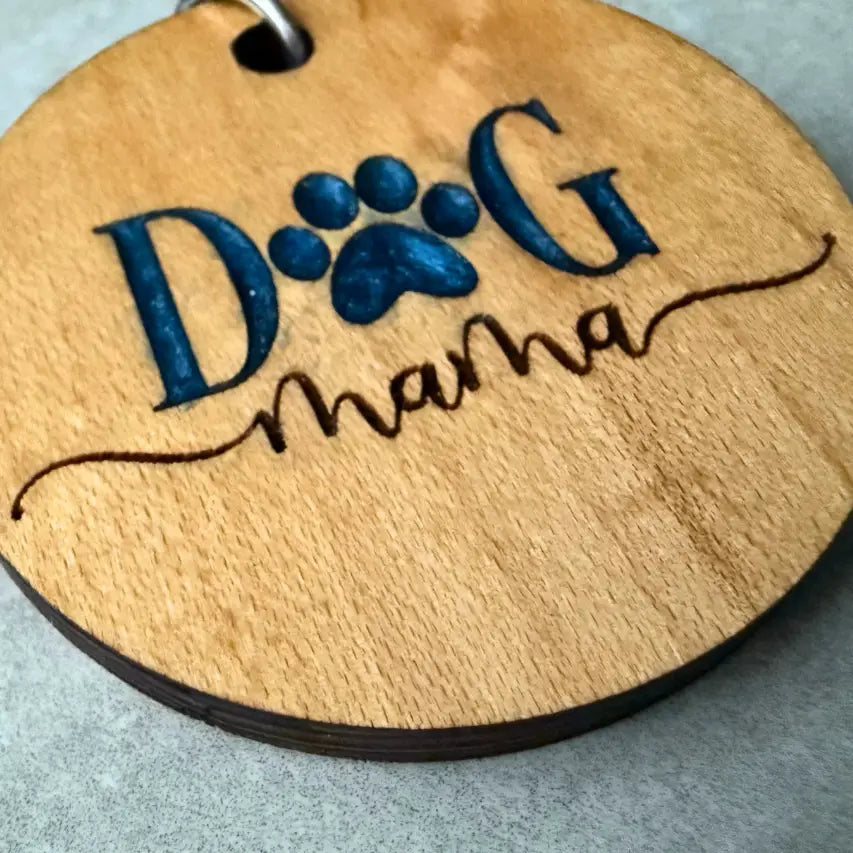 Wooden keychain with 'Dog Mama' engraving with resin fill on a gray background