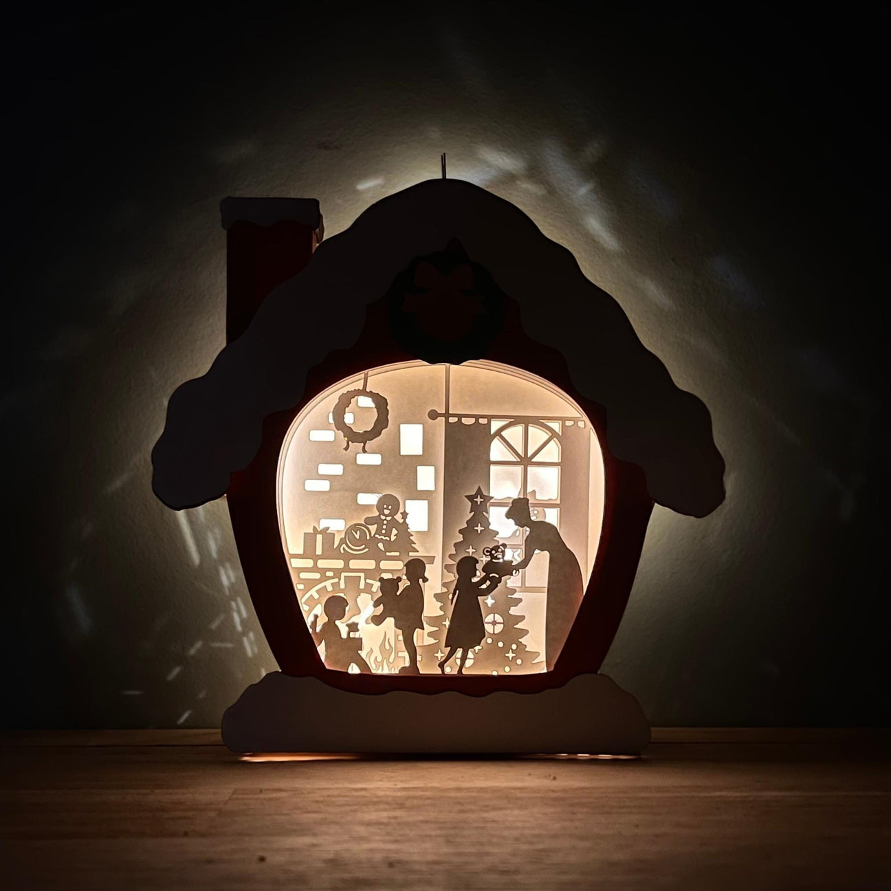 Lit up family Christmas scene against a dark background.