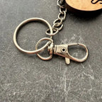 Metal keychain with a clasp on a gray surface