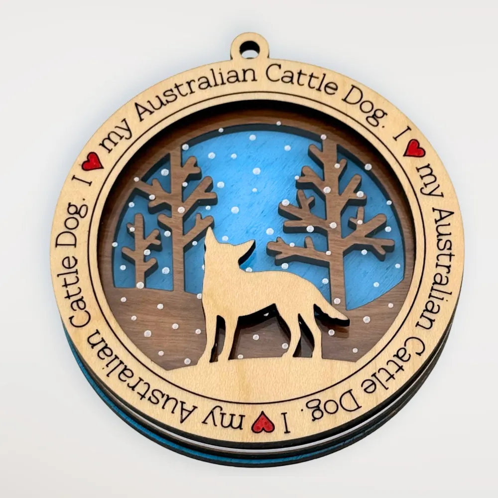 Wooden ornament with Australian Cattle Dog silhouette against a light blue background and engraved text on a white background