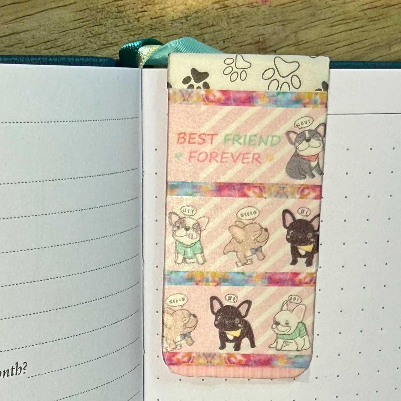 Notebook with a colorful bookmark featuring cartoon dogs and 'Best Friend Forever' text.