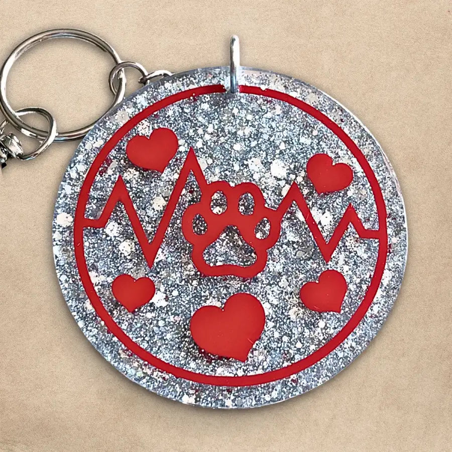 Handmade red paw and heartbeat keychain with silver glitter background, resin-sealed on both sides.