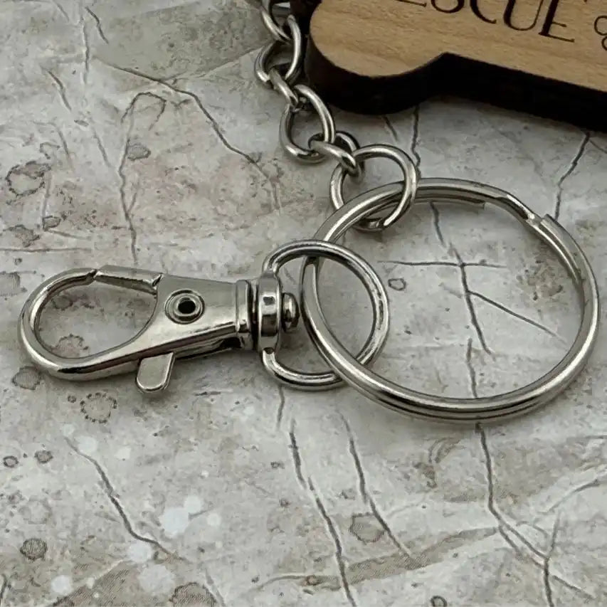 Metal keychain with clasp on a textured surface